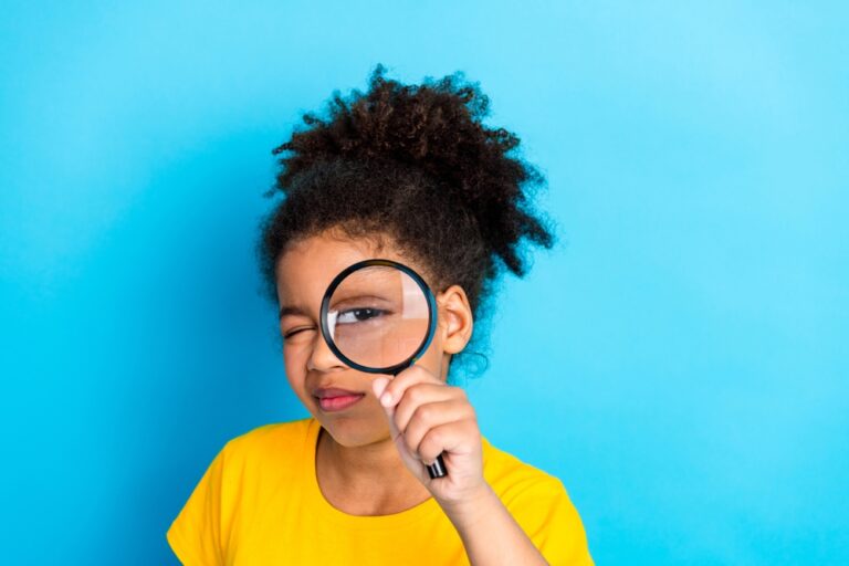 Young,Girl,With,Curly,Hair,Exploring,With,A,Magnifying,Glass